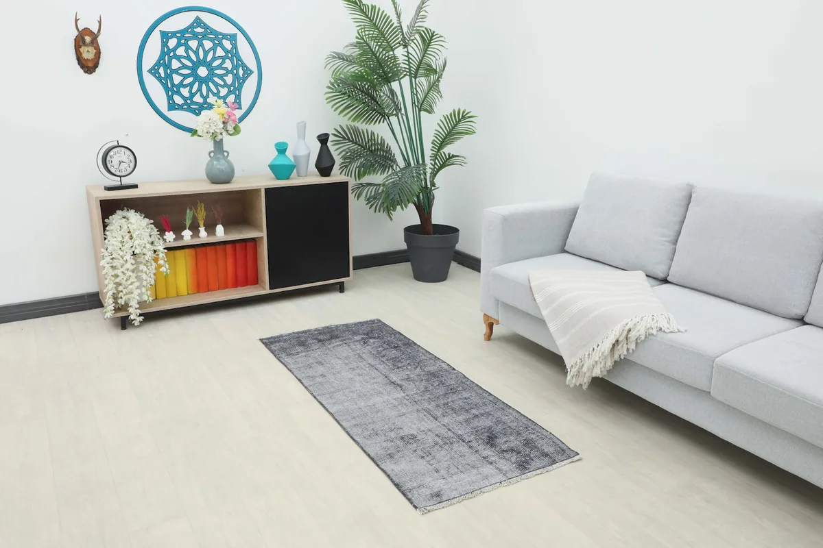 Charcoal gray runner in a modern living room setting, placed in front of a sofa and cabinet.