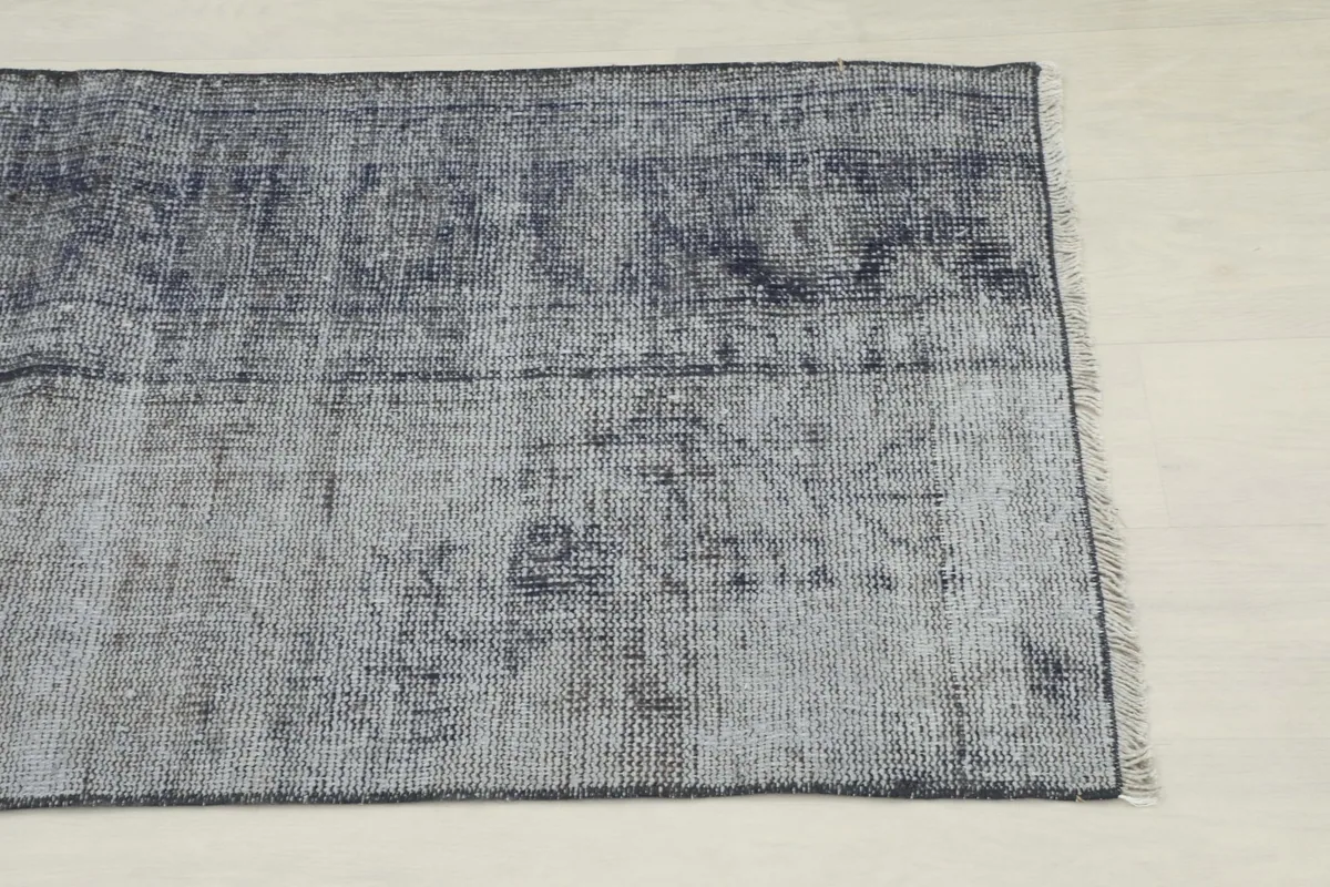 Close-up detail of one end of the runner, showing the faded charcoal gray and subtle patterns.
