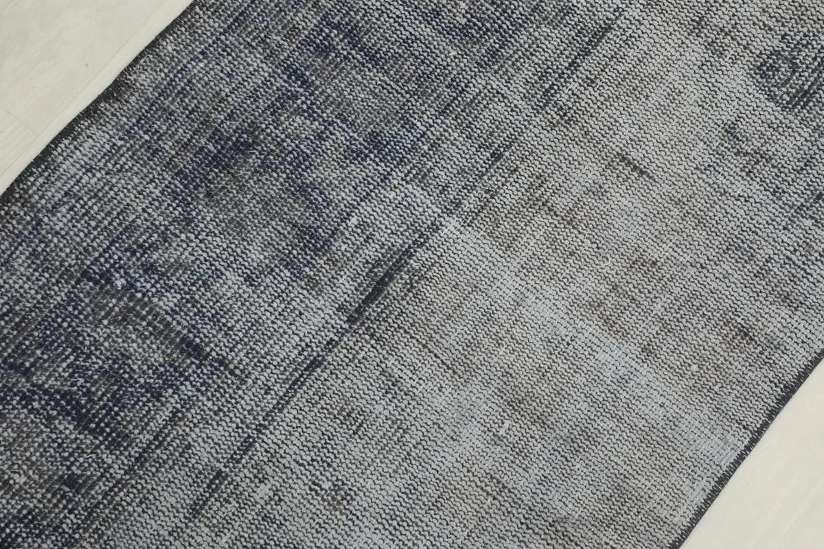 Overhead detail showing the distressed wool pile and color shifts from charcoal to lighter gray.