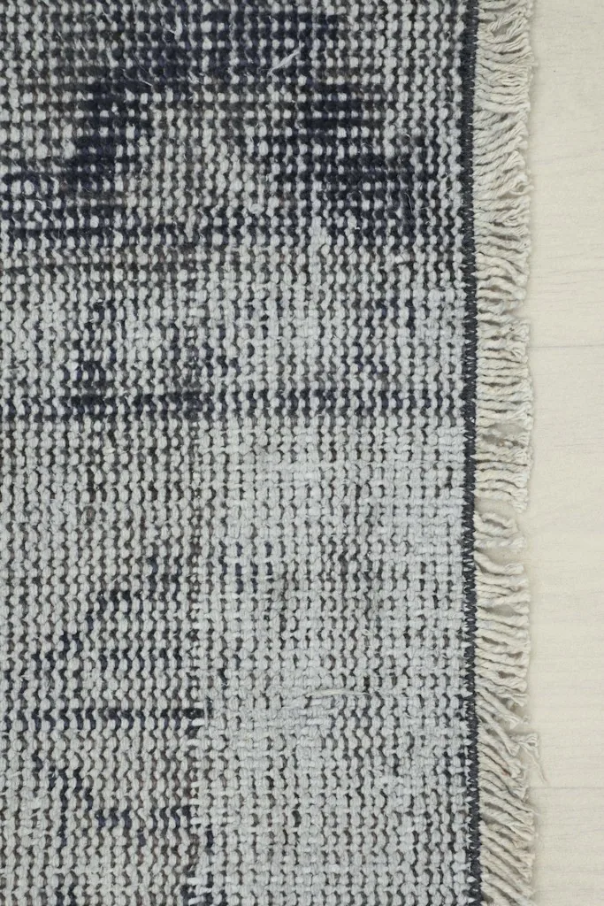 Detail of the short, light-colored fringes and the edge of the hand-knotted runner.