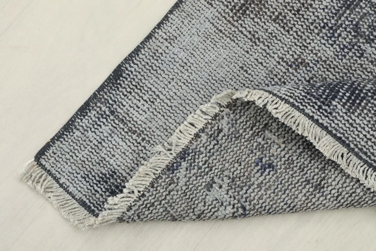 Corner of the runner folded back, showing the thickness of the rug and the reverse side.