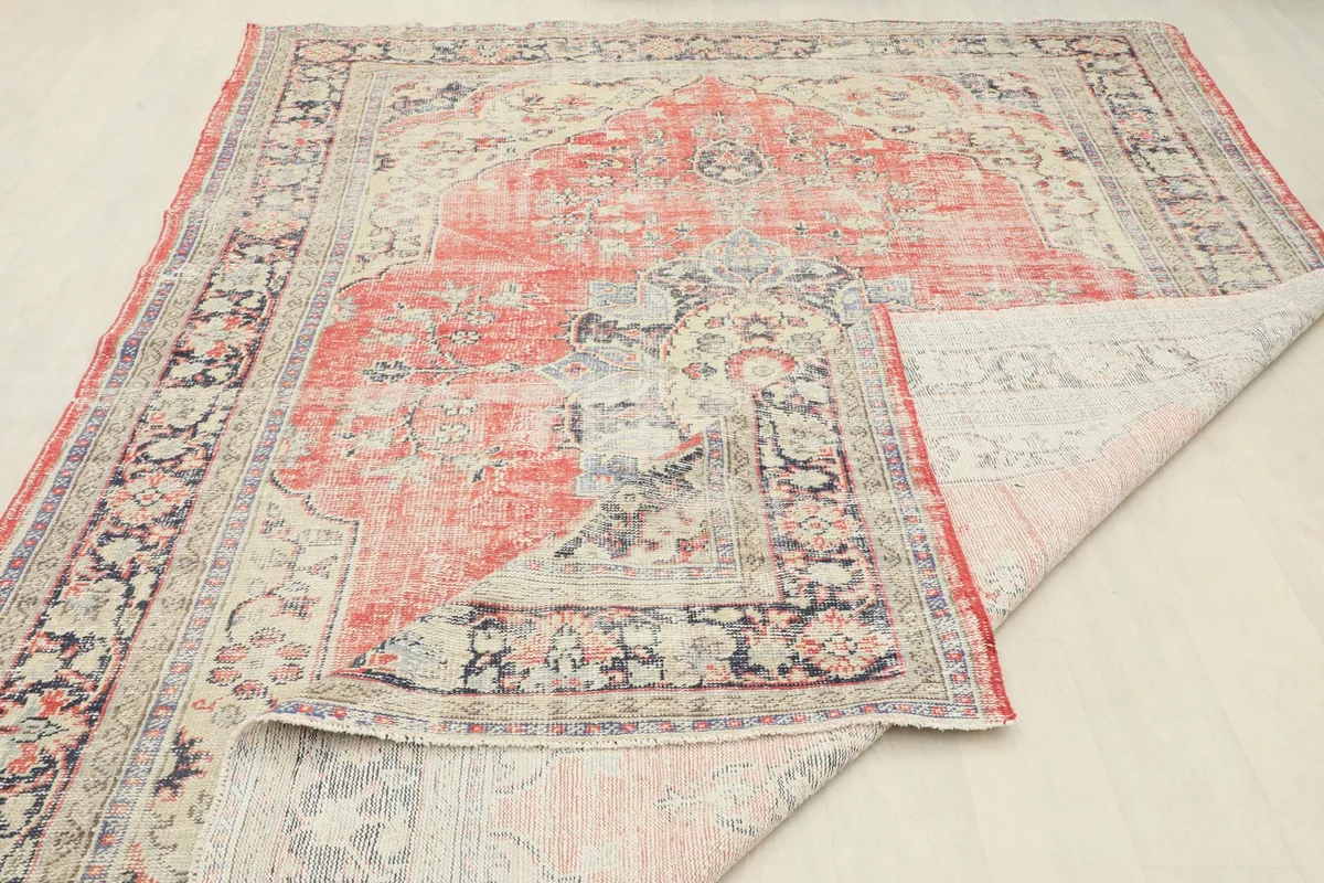 View of the rug folded back to show the reverse side and the overall pattern.
