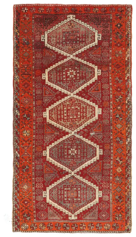 Full overhead view of a vintage red and orange geometric Anatolian rug