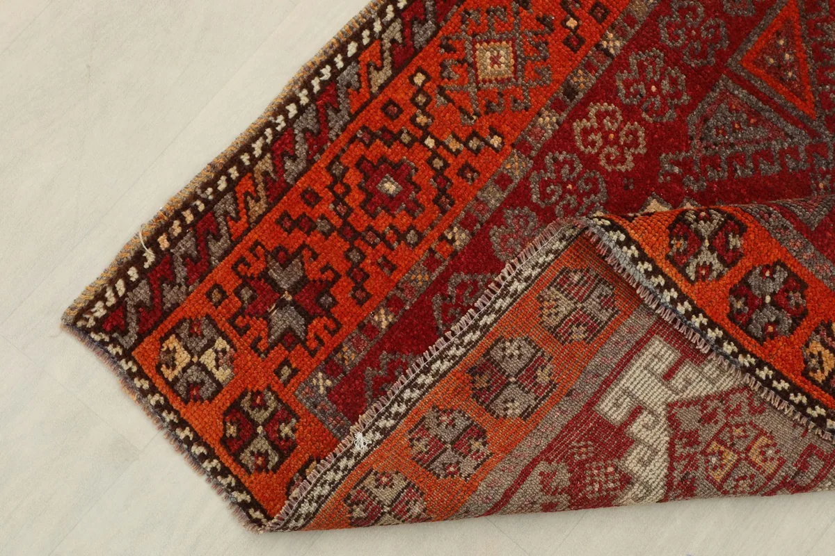 Corner of the rug folded to reveal the backside and knotting structure