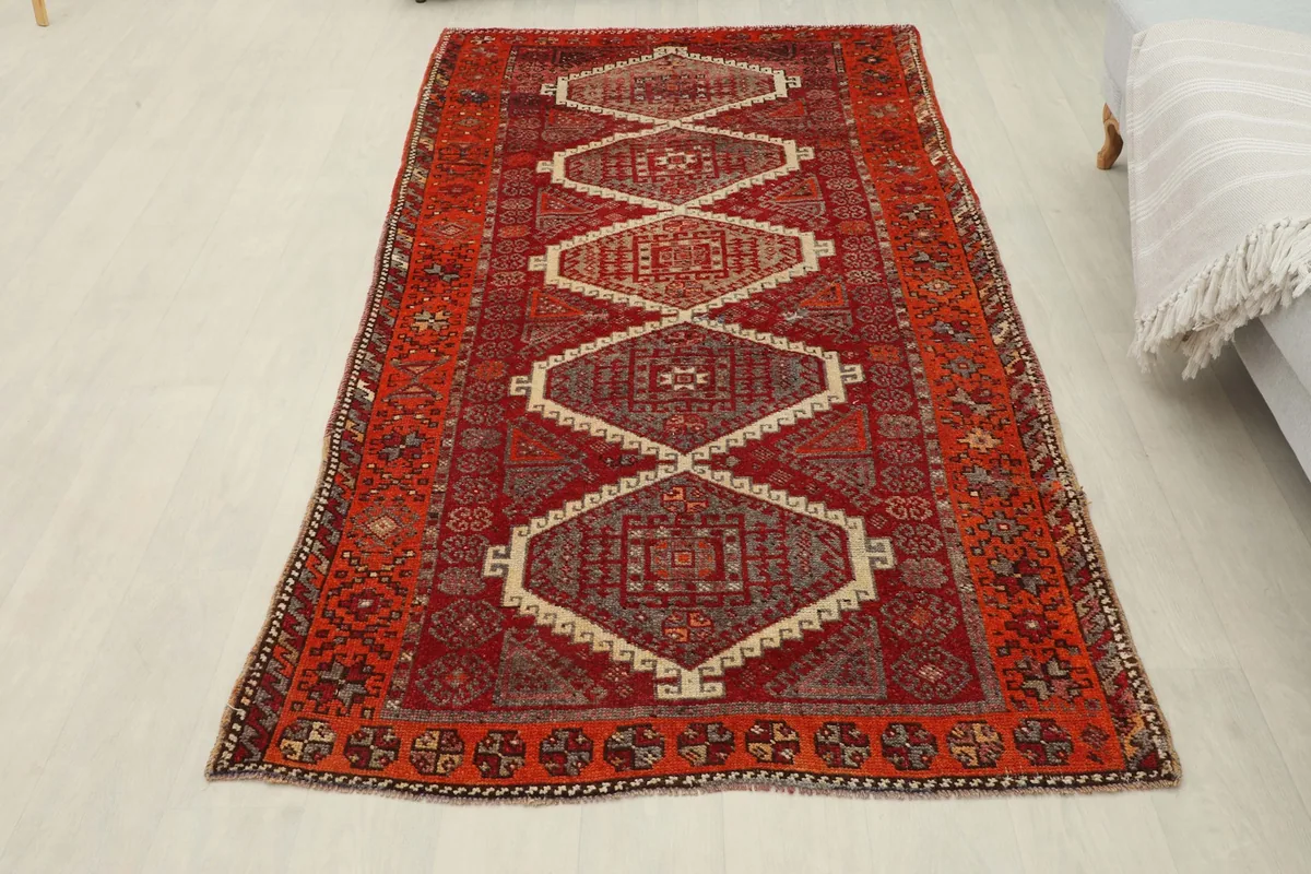 Full overhead shot of the red and orange geometric rug laid out in a room