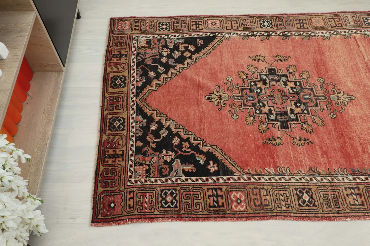 Overhead angled shot of the runner's end, showing a black medallion and the decorative border