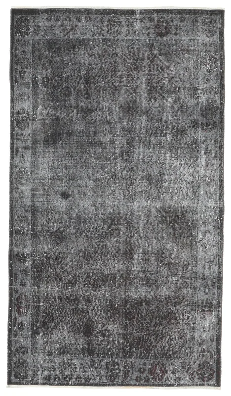 Full overhead view of the charcoal gray floral vintage Anatolian rug on a white background.