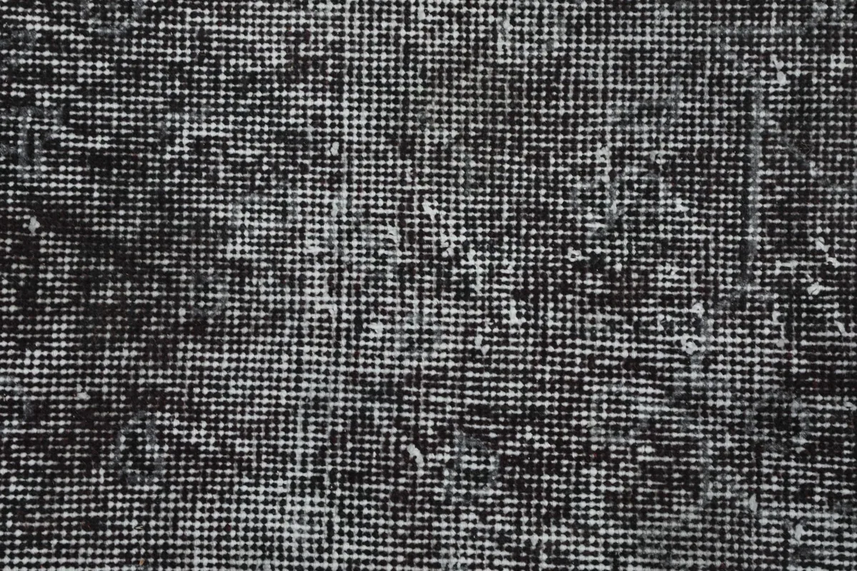 Close-up of the rug's backside, revealing the hand-knotted cotton foundation and wool pile structure.