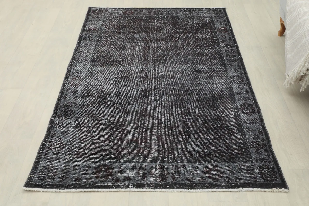 Full overhead view of the charcoal gray vintage rug, showcasing its overall appearance and shape.