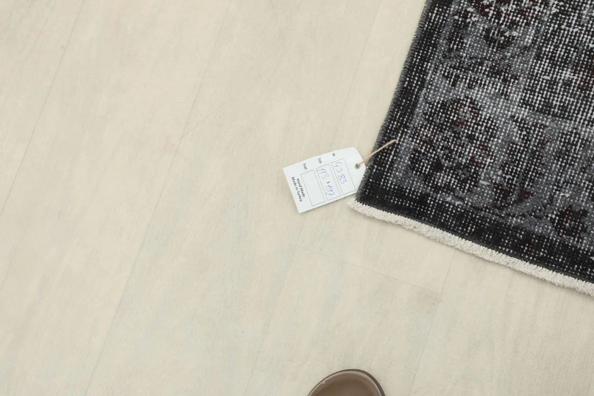Overhead view of the rug with a tag near the corner, showing product information.