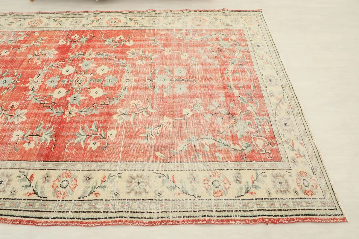 Another angle shot of the vintage rug, detailing the distressed texture and color variations