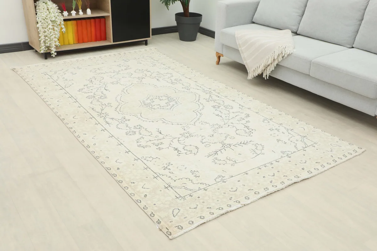 Ivory Medallion Anatolian Rug laid out in a room, showing its full length and patterns.