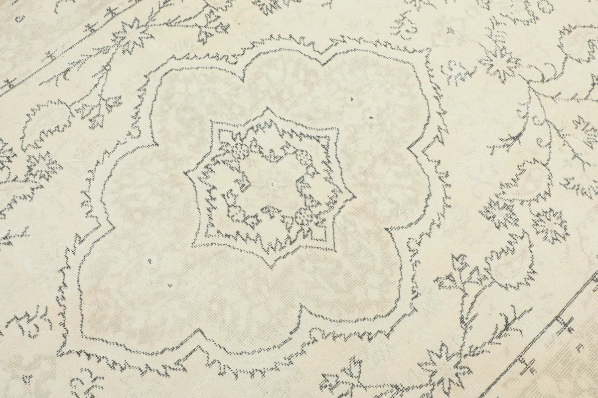 Close-up of the central medallion and surrounding floral patterns on the ivory rug.