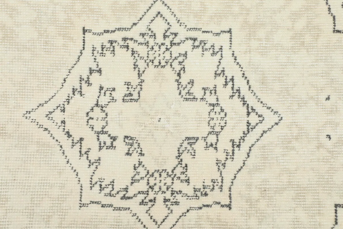 Detailed view of the intricate gray geometric patterns within the rug's central design.