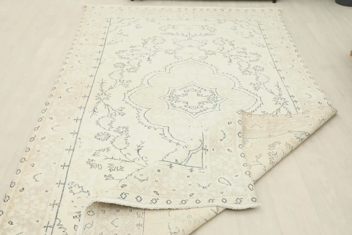 Ivory Medallion Anatolian Rug partially folded, revealing the texture and patterns.