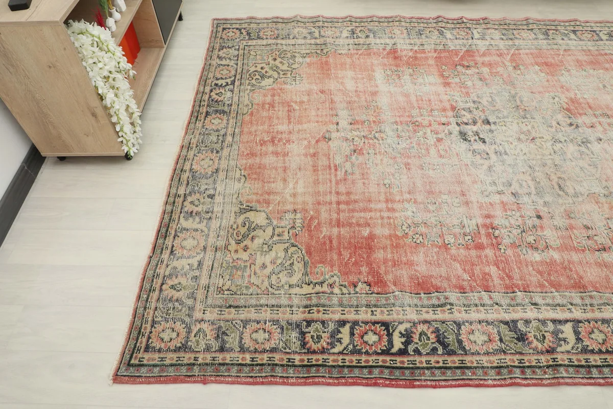 Corner view of the vintage Anatolian rug, highlighting the worn rose field and detailed border design.