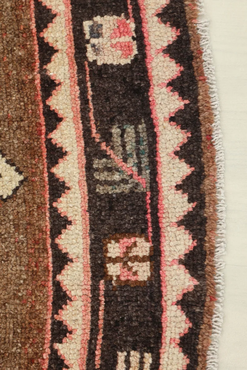 Close-up of the side border of the Beige Brown Tribal Anatolian Rug, showing pink and black details.