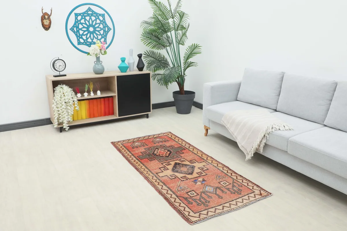 Small rust geometric area rug in a modern living room setting with a light gray couch
