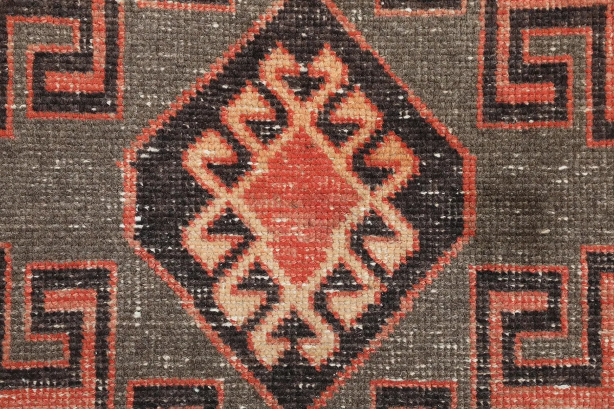 Extreme close-up of the central diamond motif, revealing wool texture and color variations
