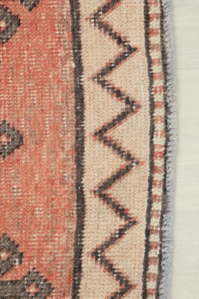 Close-up of the tan and charcoal zigzag border pattern along the side of the rug