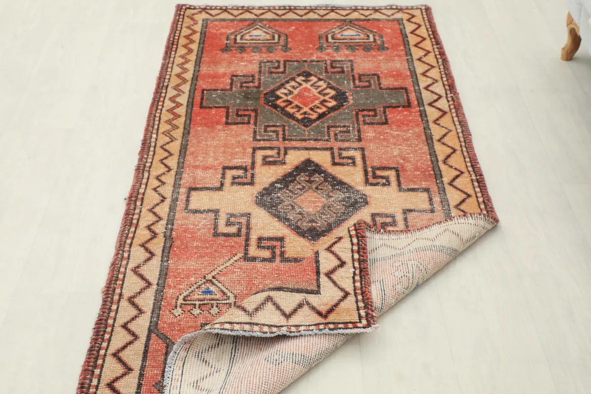 The rug partially folded to show the back and the hand-knotted construction