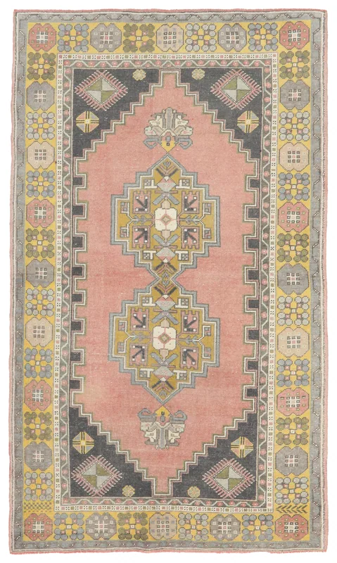 Full overhead view of a vintage Anatolian rug with rose field, charcoal corners, and geometric patterns.