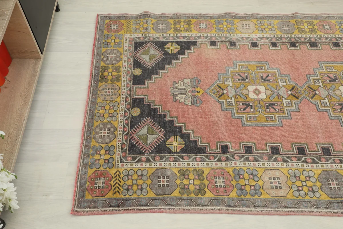 Close-up angle view of the upper left section of the rug, showing the charcoal corner and part of the border.