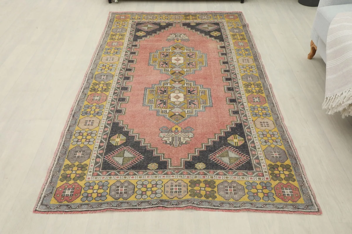 Full overhead view of the vintage Anatolian rug on a light floor, showing its entire design and colors.