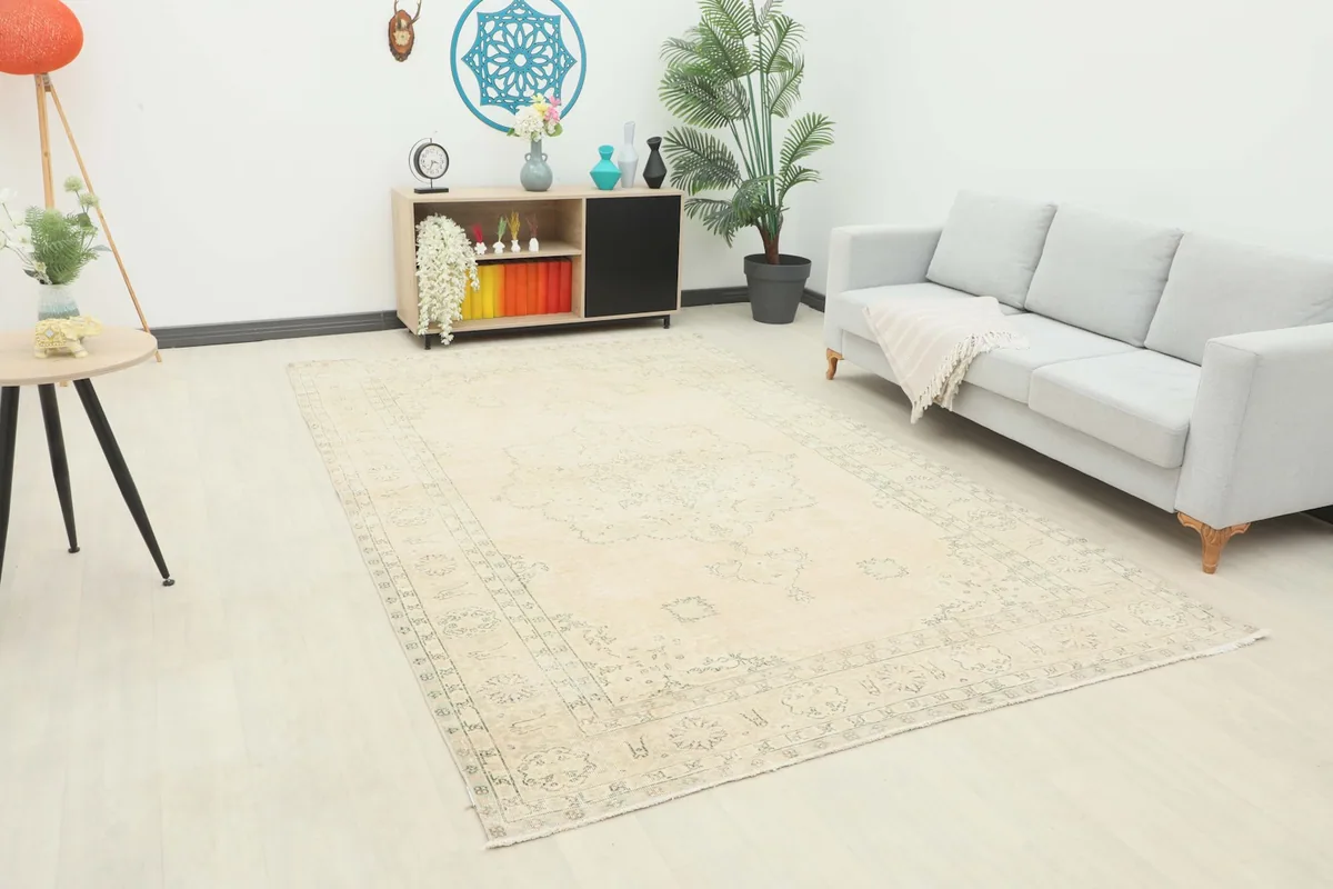 Vintage Anatolian rug laid out in a modern living room setting with a light gray sofa and wooden furniture.