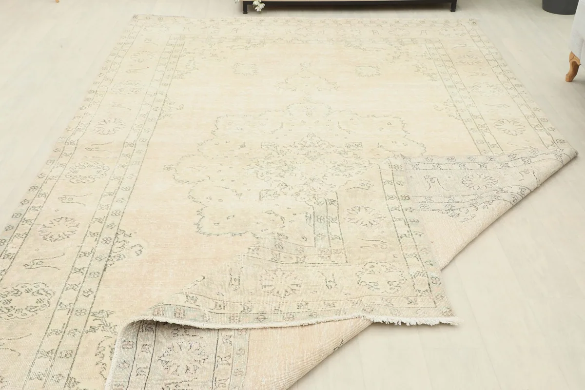 Rug partially folded, showing the flexibility and thickness of the wool pile on cotton foundation.