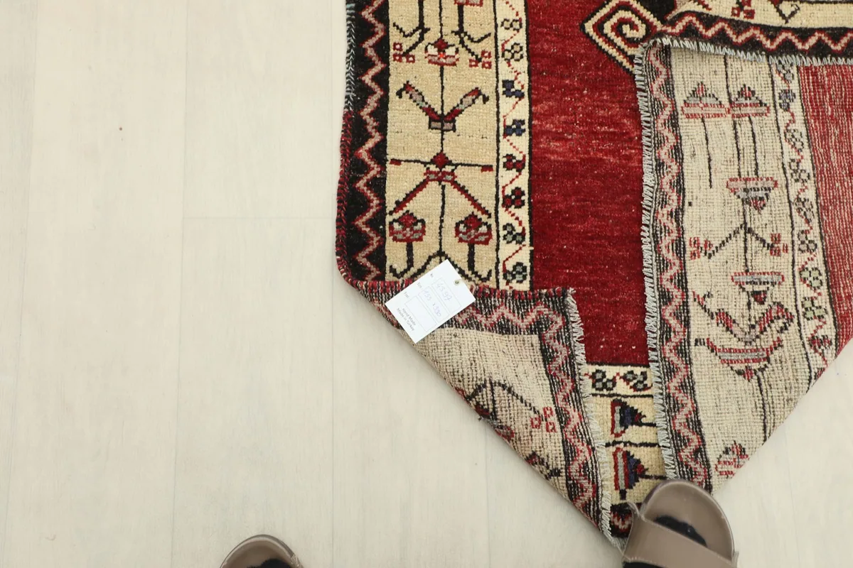 Overhead view of the rug's back and foundation, with a size tag visible