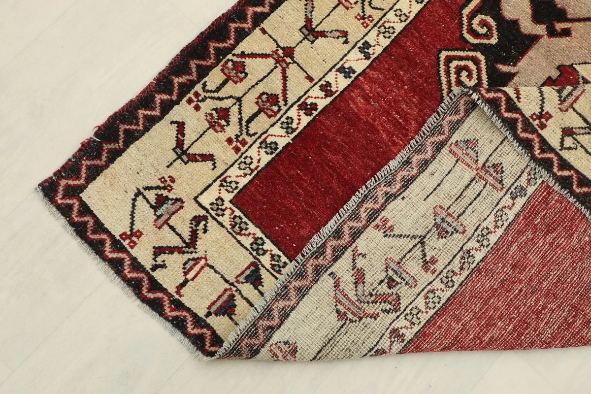 Corner of the runner rug folded back, revealing the cotton foundation