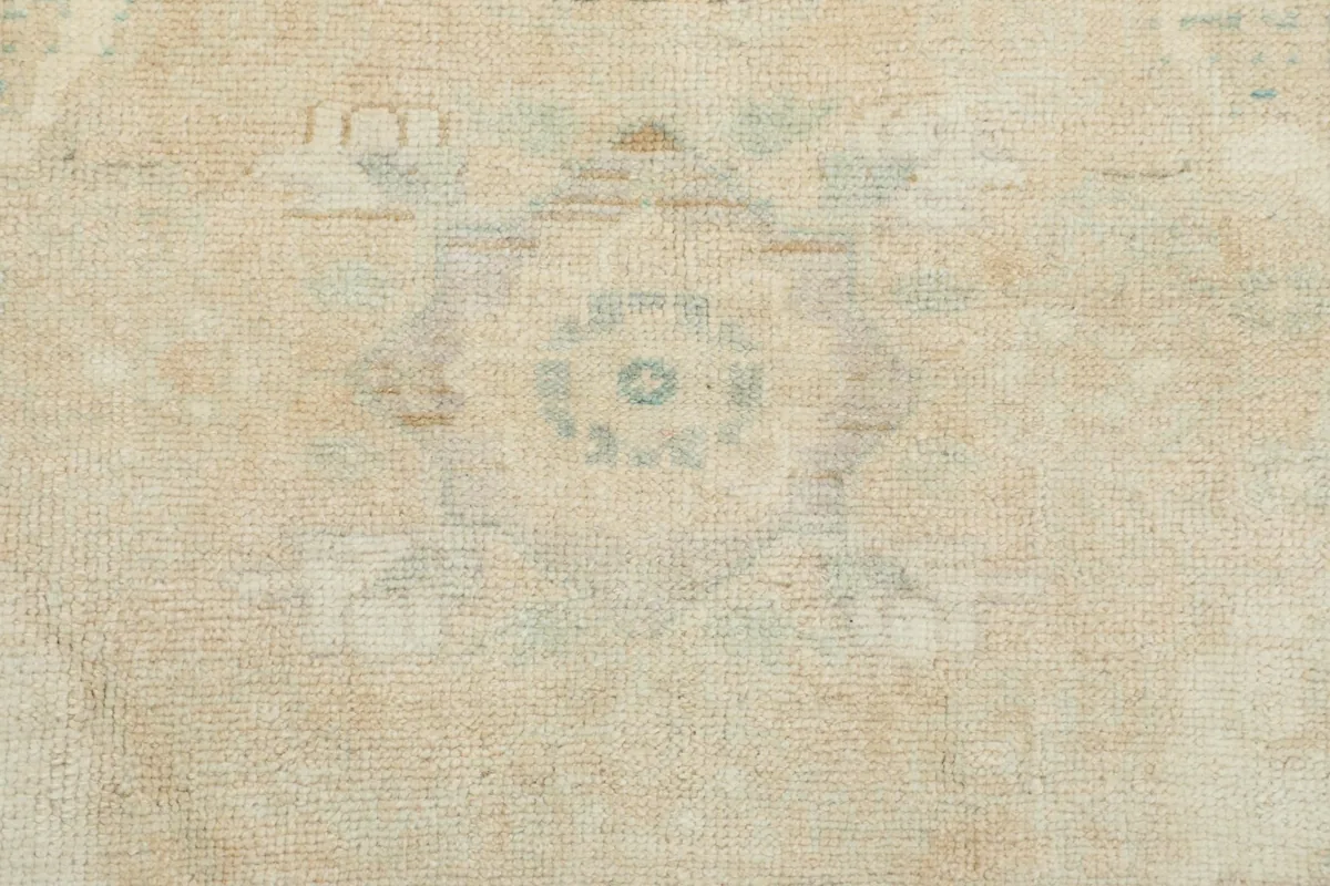 Close-up of a faded blue and tan motif within the rug's pattern