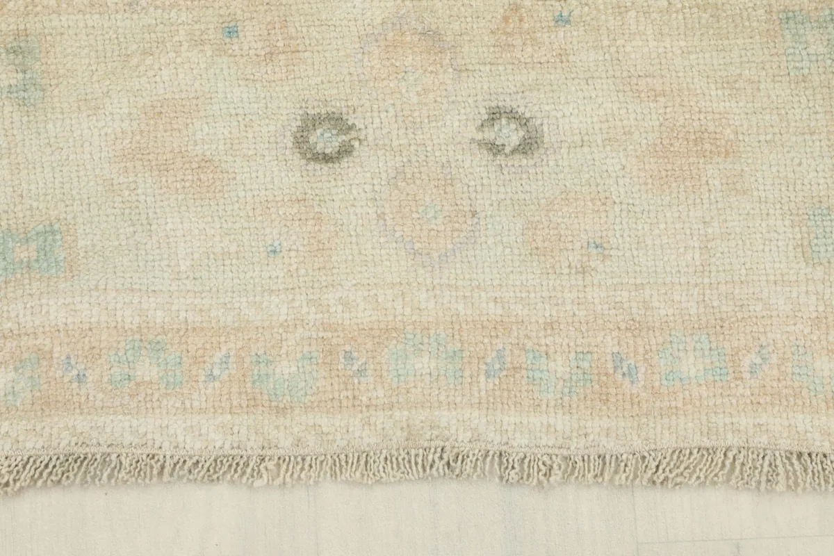 View of the rug's short fringe and a section of the border with circular motifs