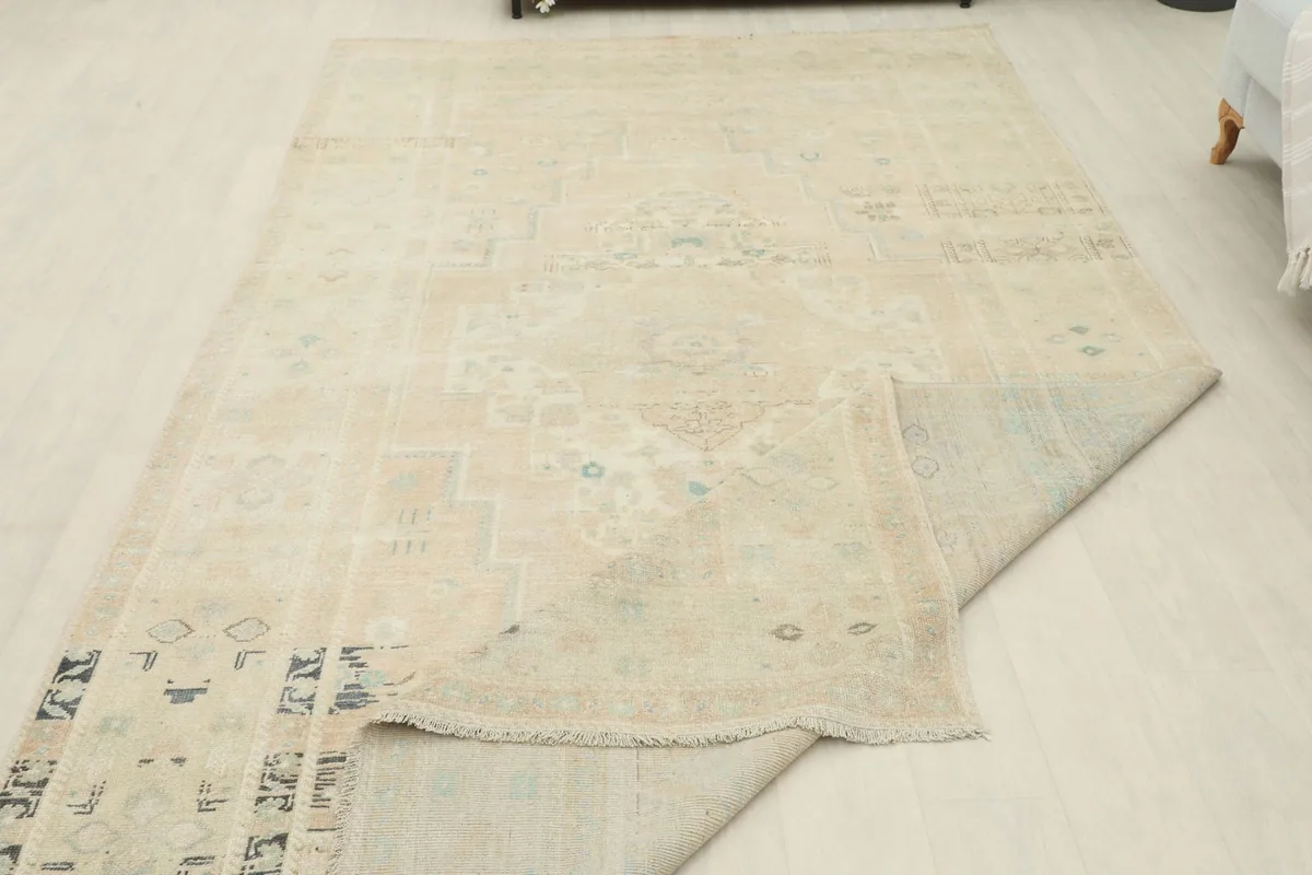 Rug partially folded, displaying its flexibility and the reverse side of the wool pile
