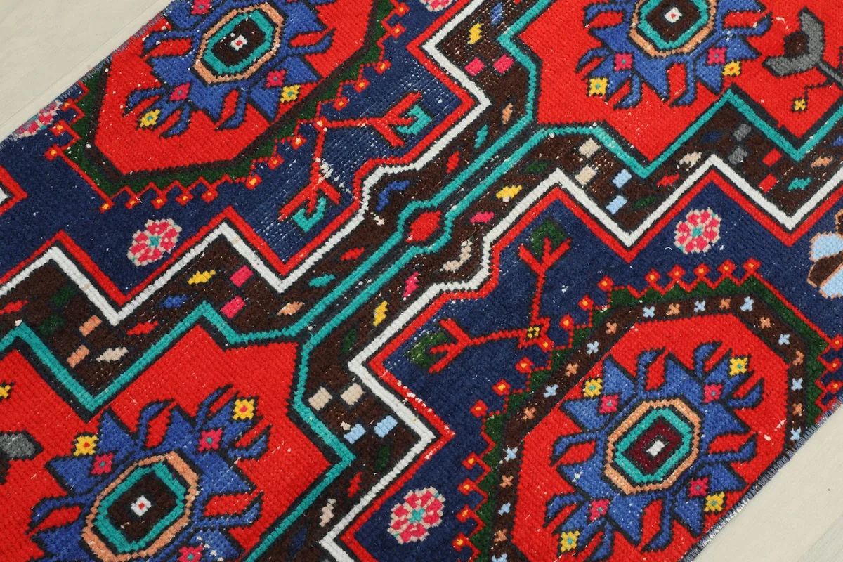 Detailed view of the central geometric motifs in red, navy, and multicolor