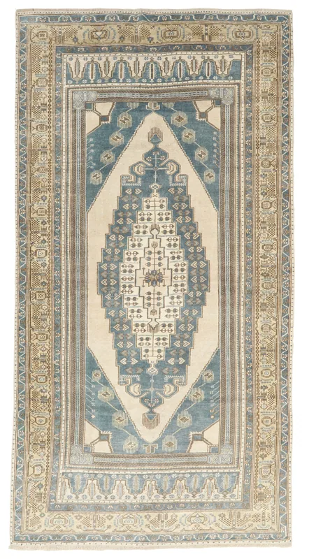 Full top view of the 5'1" x 9'7" vintage Anatolian area rug with a blue and beige geometric medallion design.