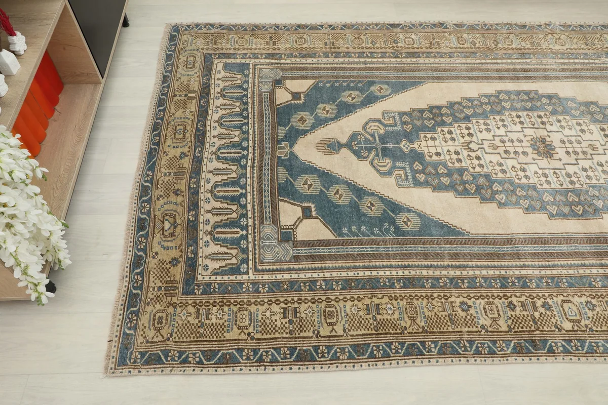 Detail view of the rug's border and corner, highlighting the brown and olive accents.