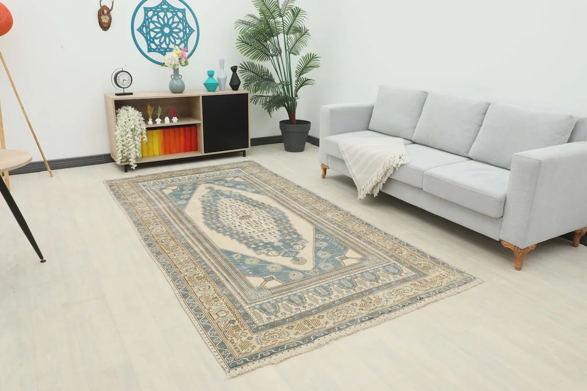 An angle view of the vintage Anatolian rug in a living room with a sofa and side table.