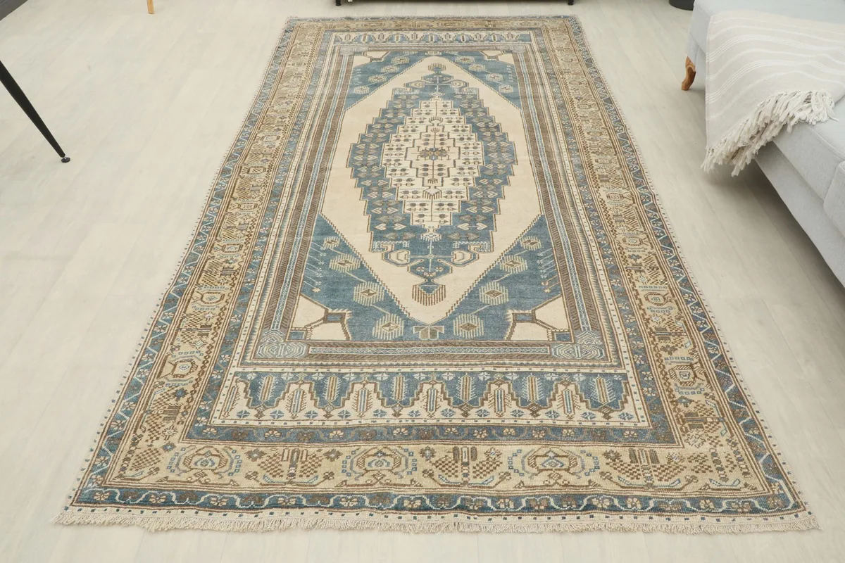 Overhead view of the blue and beige vintage Anatolian rug laid out in a room setting.