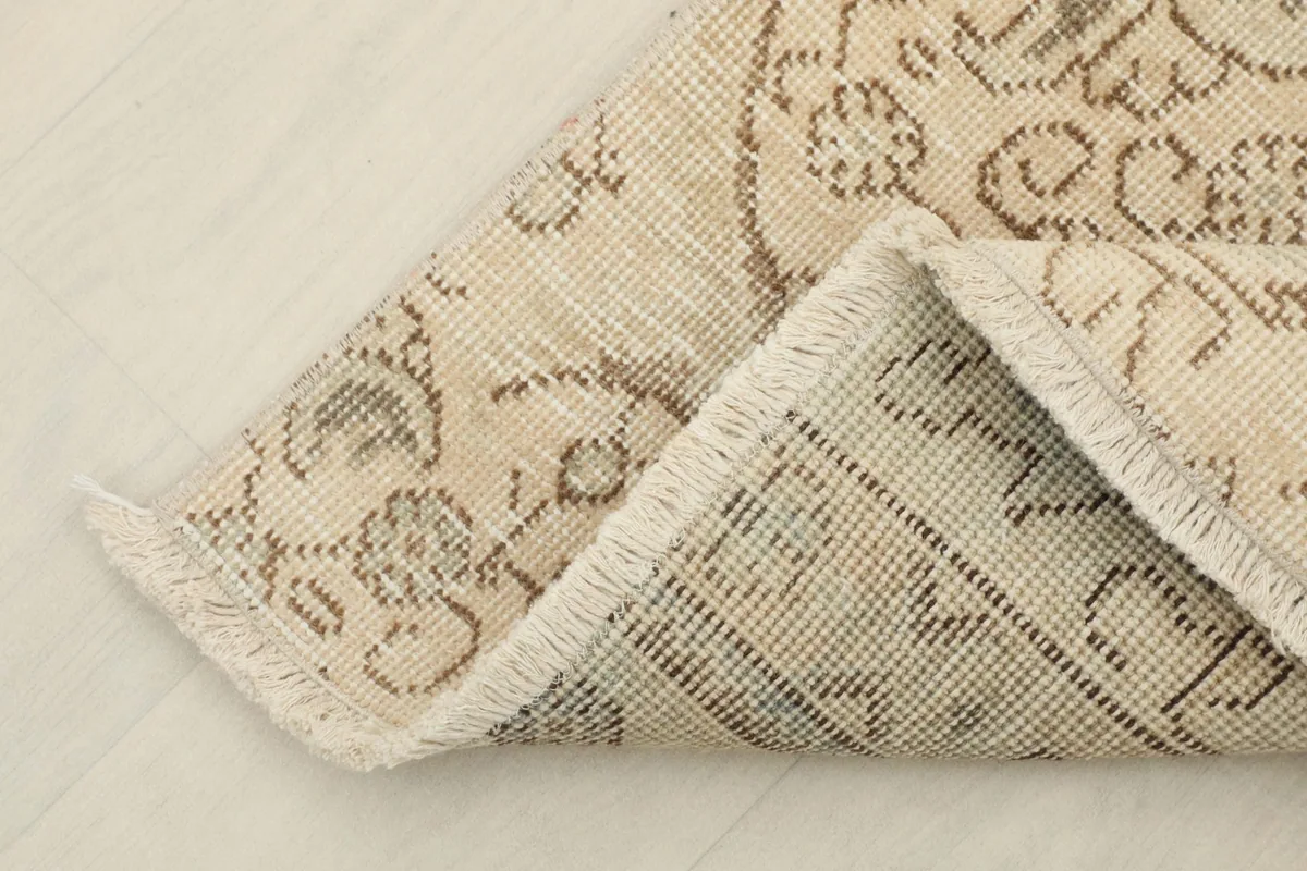 View of the back of the rug, showing the cotton foundation and the hand-knotted construction.