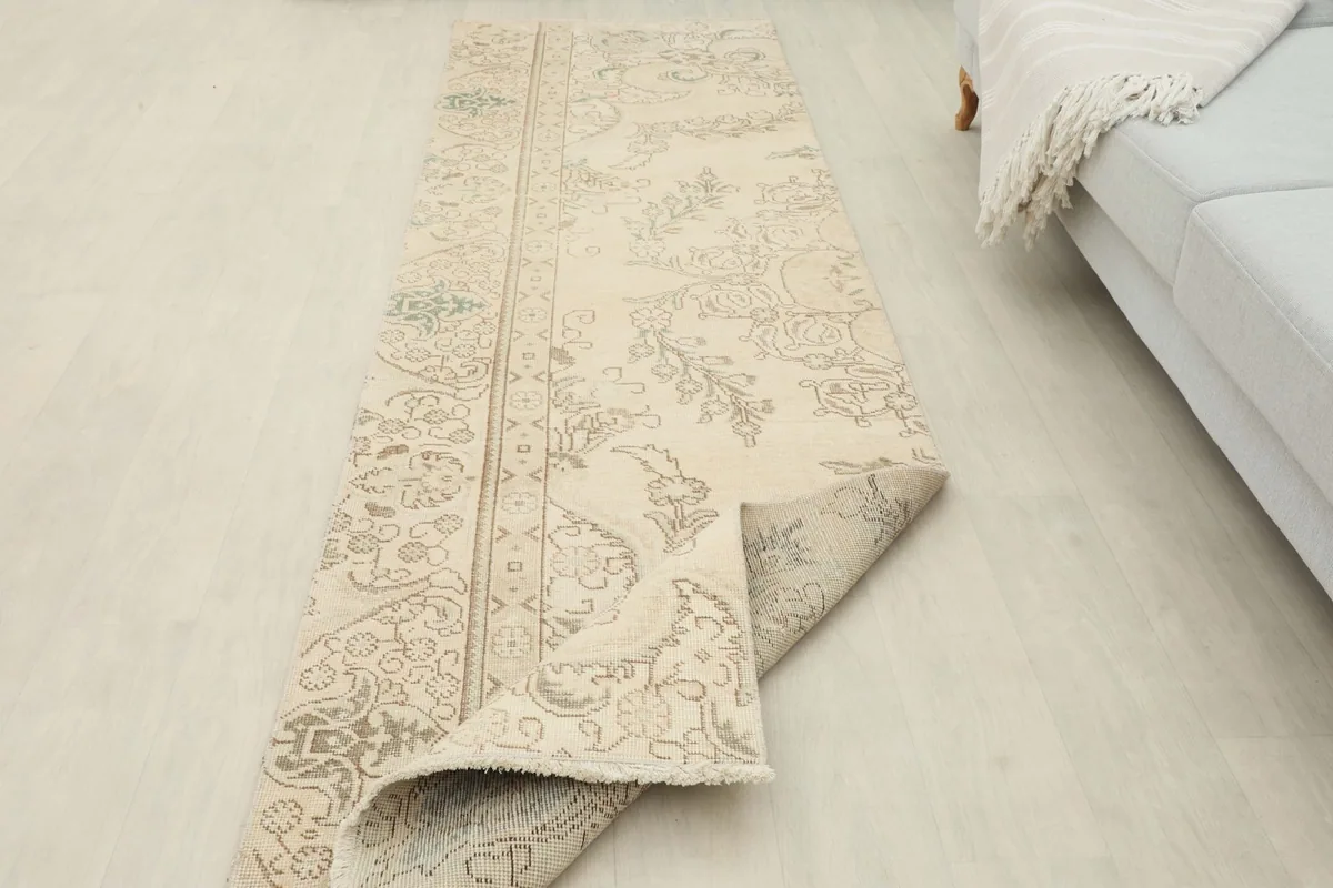 The runner rug partially folded back, demonstrating its flexibility and construction.
