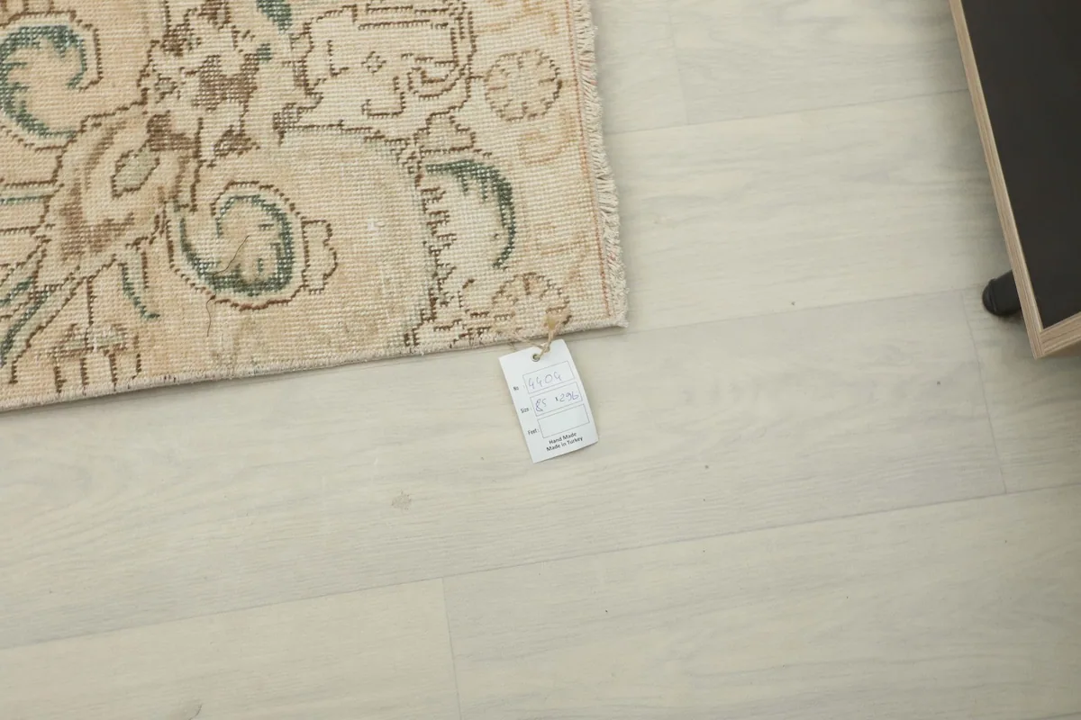 Corner of the rug with the product tag visible, laid on a light floor.