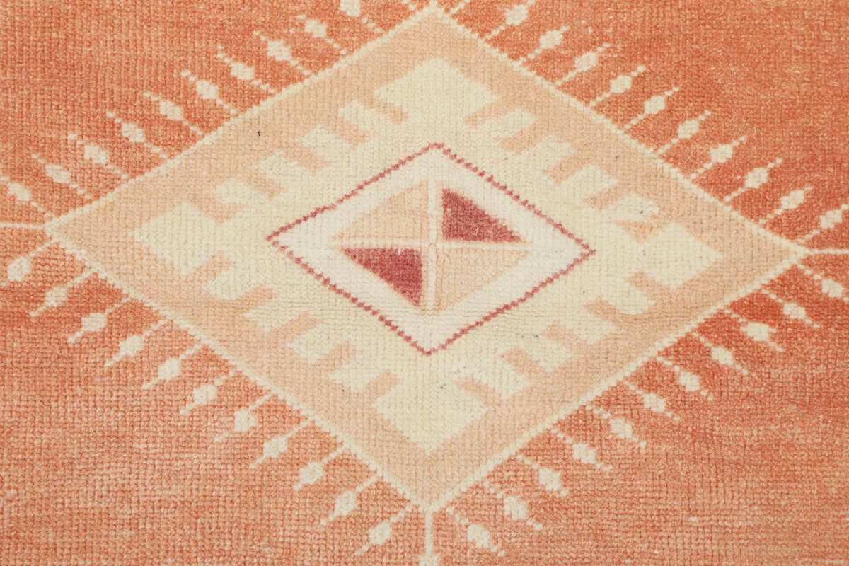 Close-up of the intricate geometric motifs within the central medallion of the rug