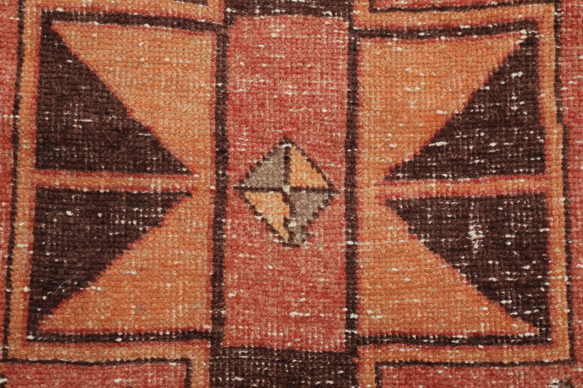 Close-up of a smaller geometric motif within the rug, showcasing the hand-knotted texture and color variations.