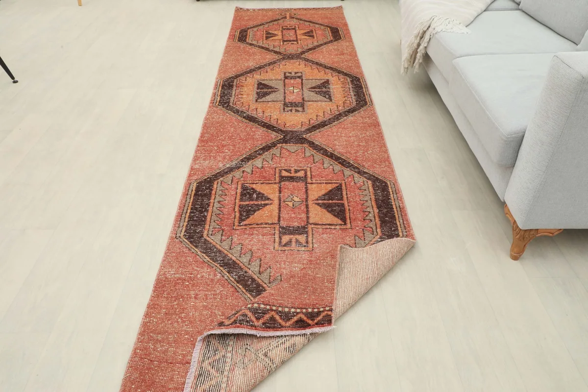 Full length view of the runner with one end folded back, showing the back of the rug and the wool pile.