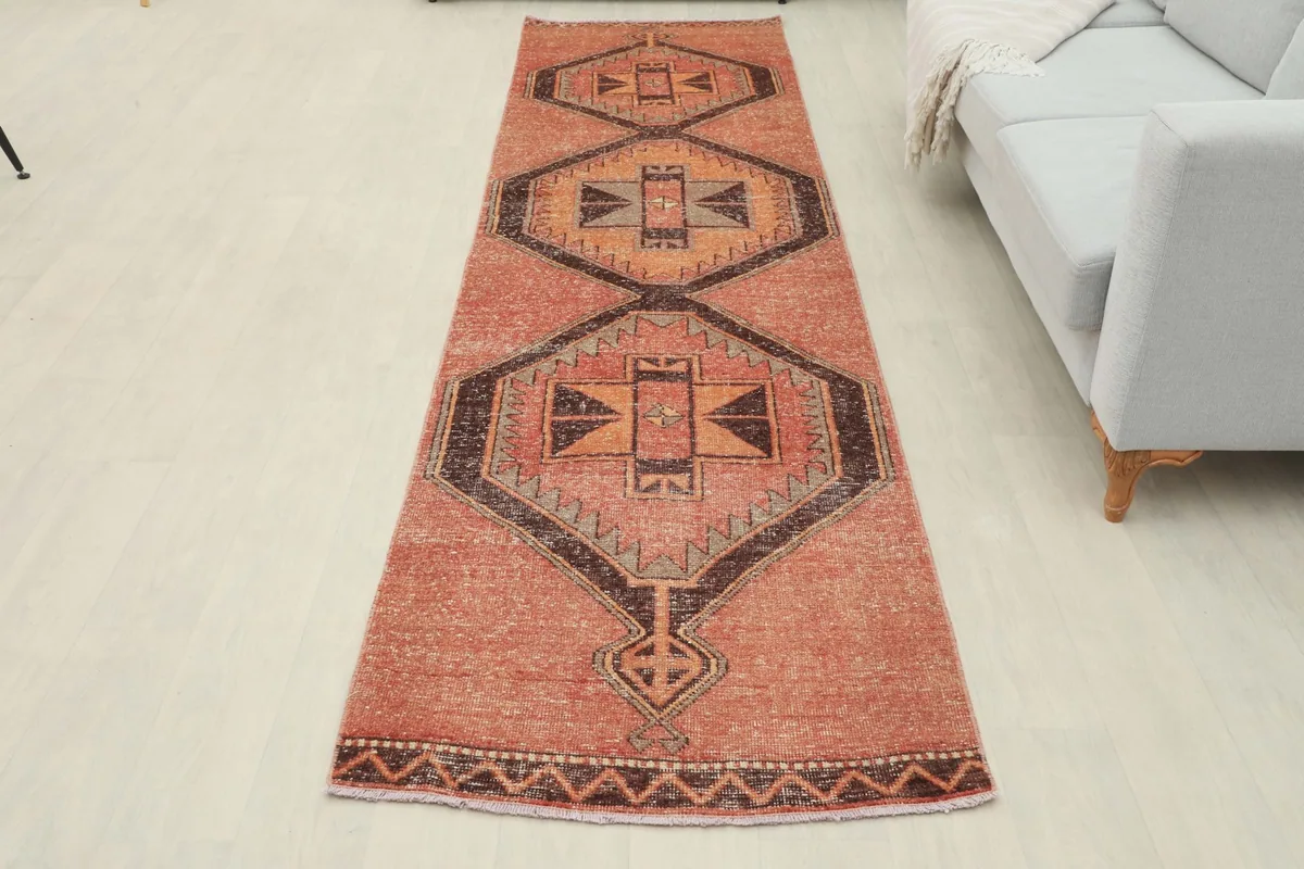 Overhead view of the entire runner rug as it lies in a room setting, emphasizing its long, narrow shape.