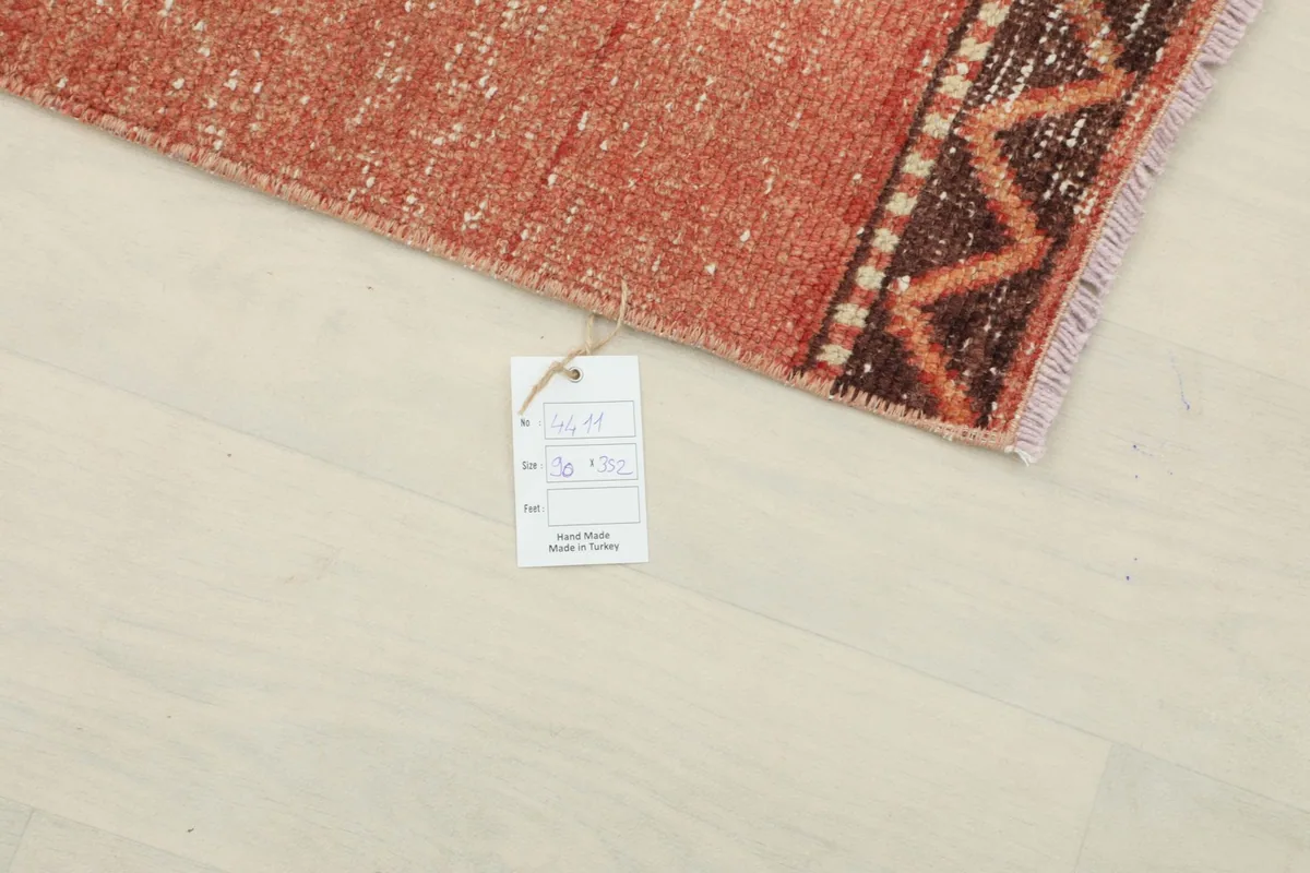 Detail showing the product tag attached to the corner of the rug, indicating its origin and material.