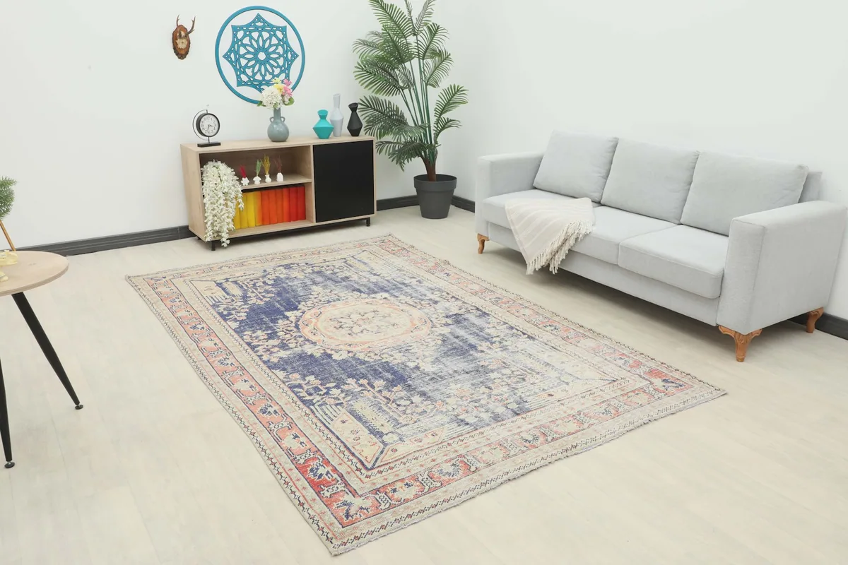 Vintage navy and rose rug displayed in a living room setting with a light gray sofa and modern decor.