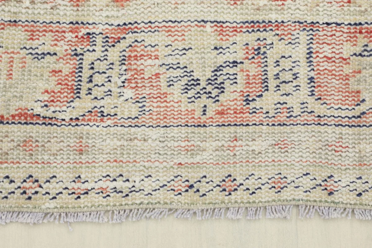 Detail of the rug's border and short, natural fringes at the end.